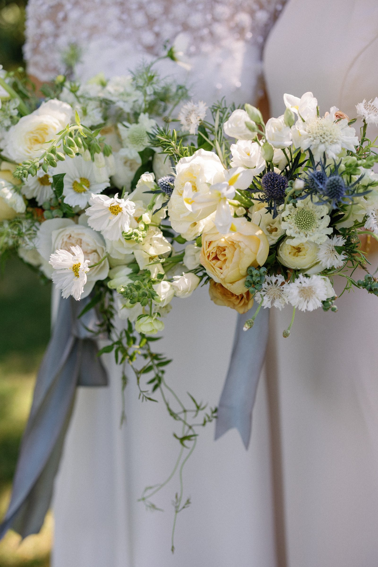 A bride holding wedding florals by Golden Thistle Design